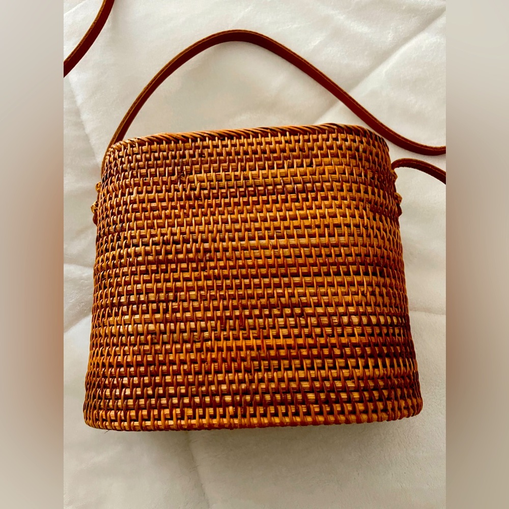 Rectangular rattan bag with top closure.